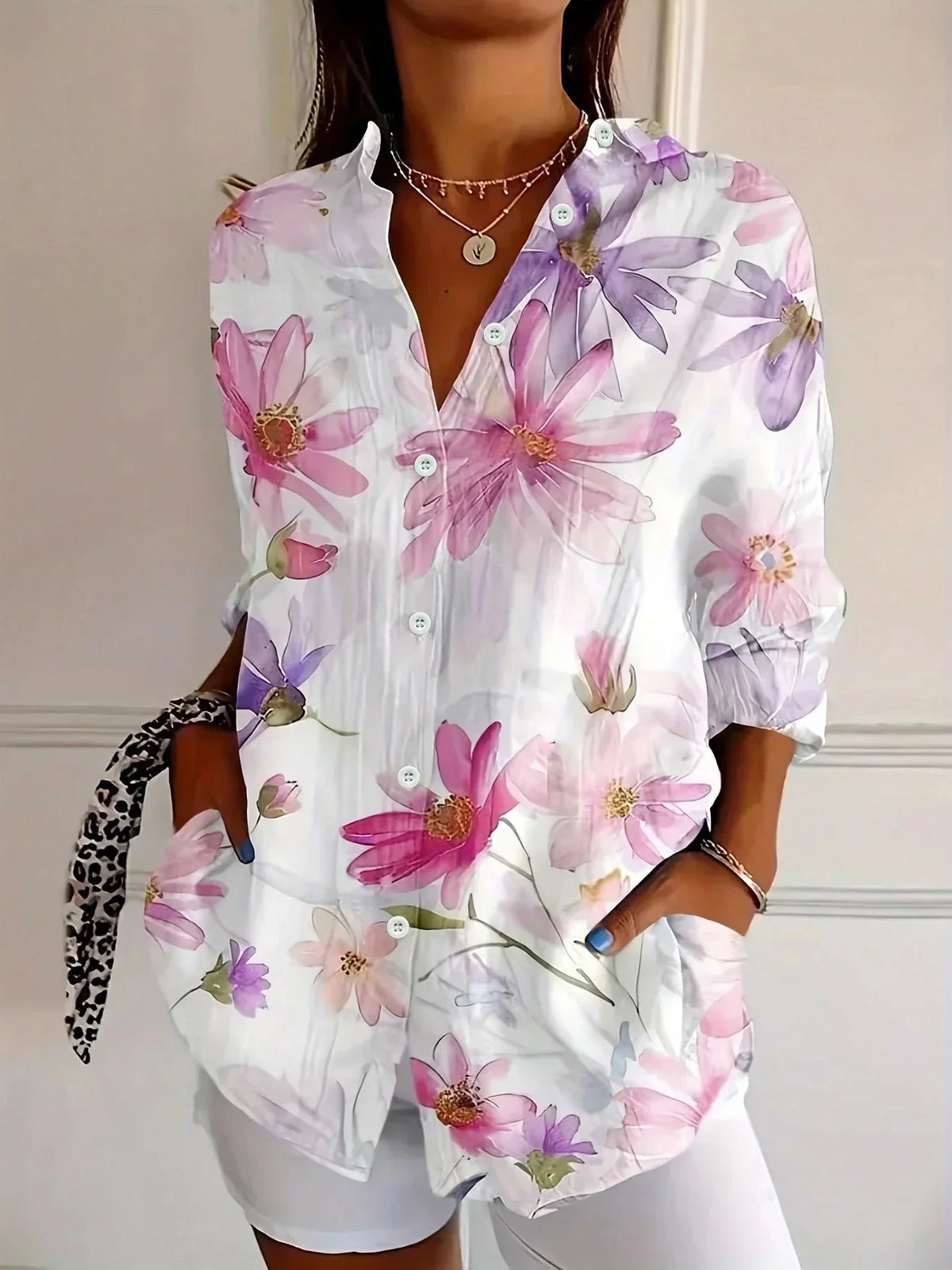 Blusa de mujer blanca con flores grandes moradas y botones al frente