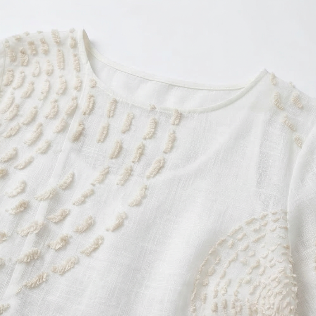 Vestido blanco de mujer con bordado en relieve en la zona superior y escote redondo