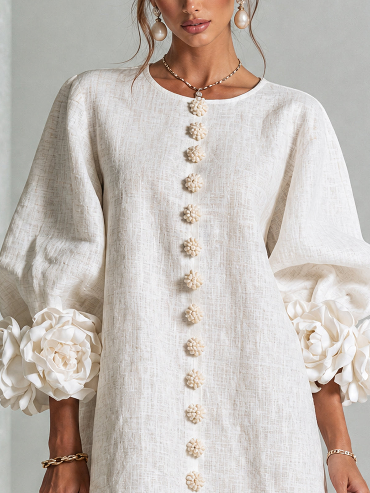 Vestido corto blanco de lino con bordado de botones dorados y flores en las mangas