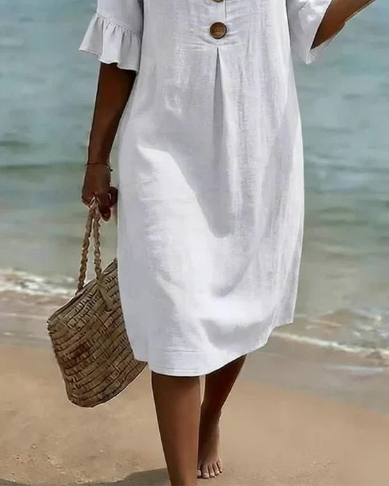 Vestido blanco con botones de madera y dobladillo recto; manga abullonada y volante