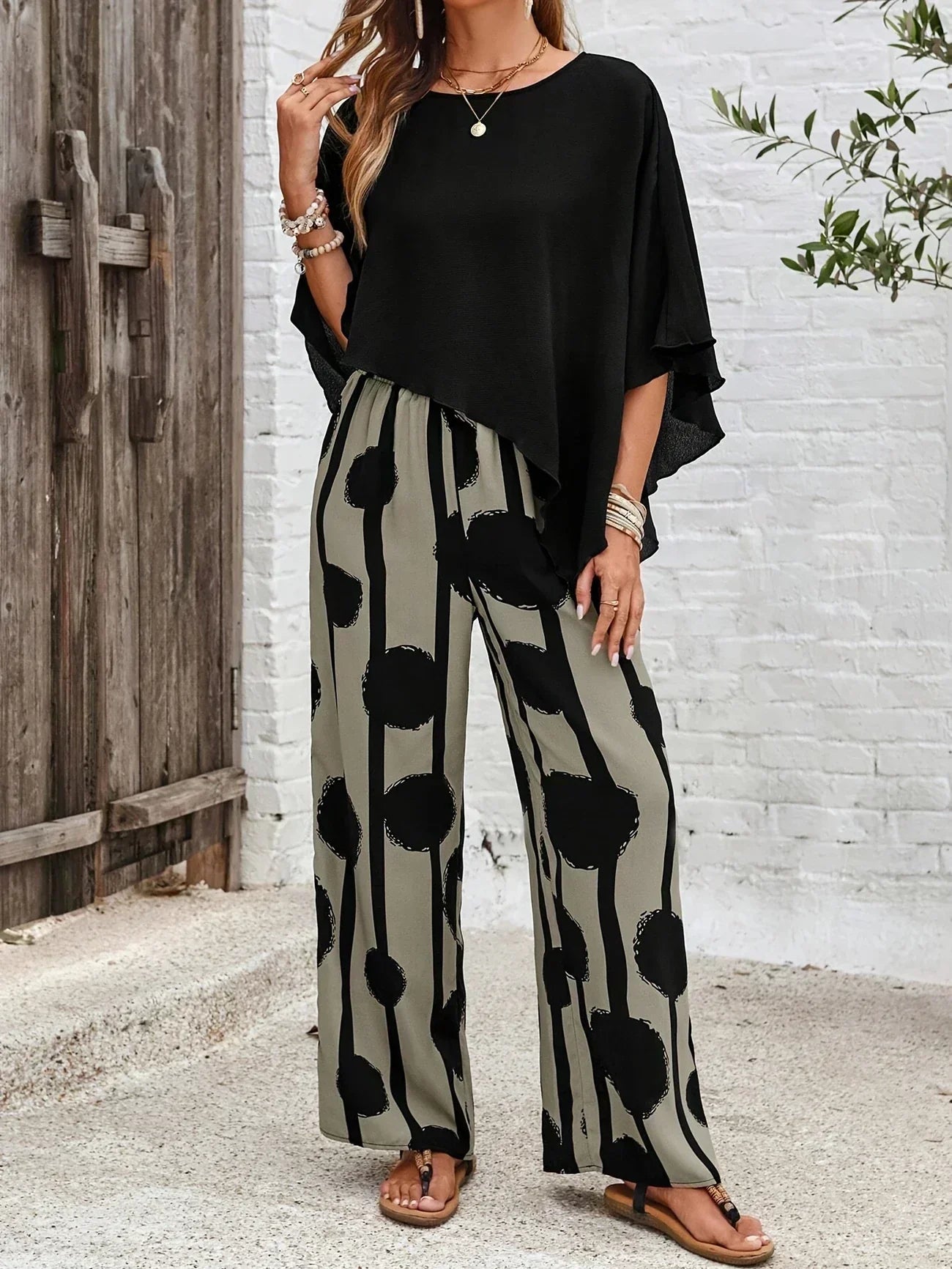 Conjunto boho negro con top asimétrico y pantalón ancho fluido de círculos grandes