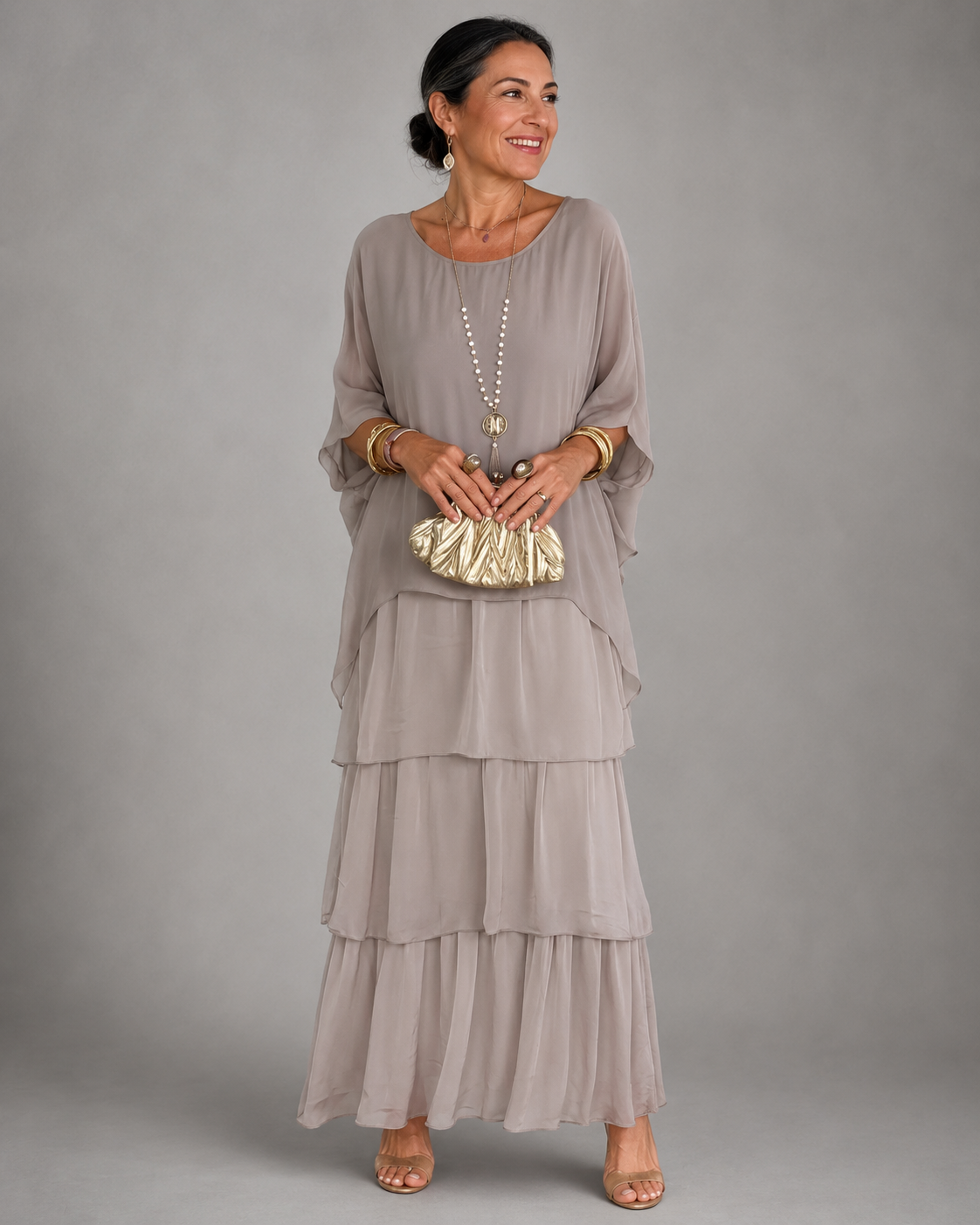 Vestido largo gris claro fluido con volantes escalonados y mangas tipo capa