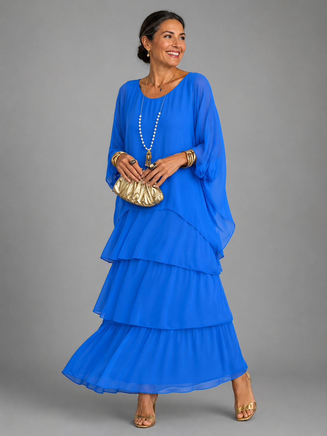 Vestido largo azul fluido con volantes escalonados y mangas tipo capa