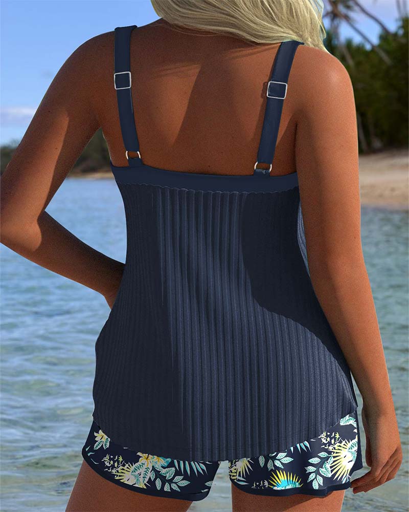 Tankini azul marino por detrás, con tirantes y short floral a juego