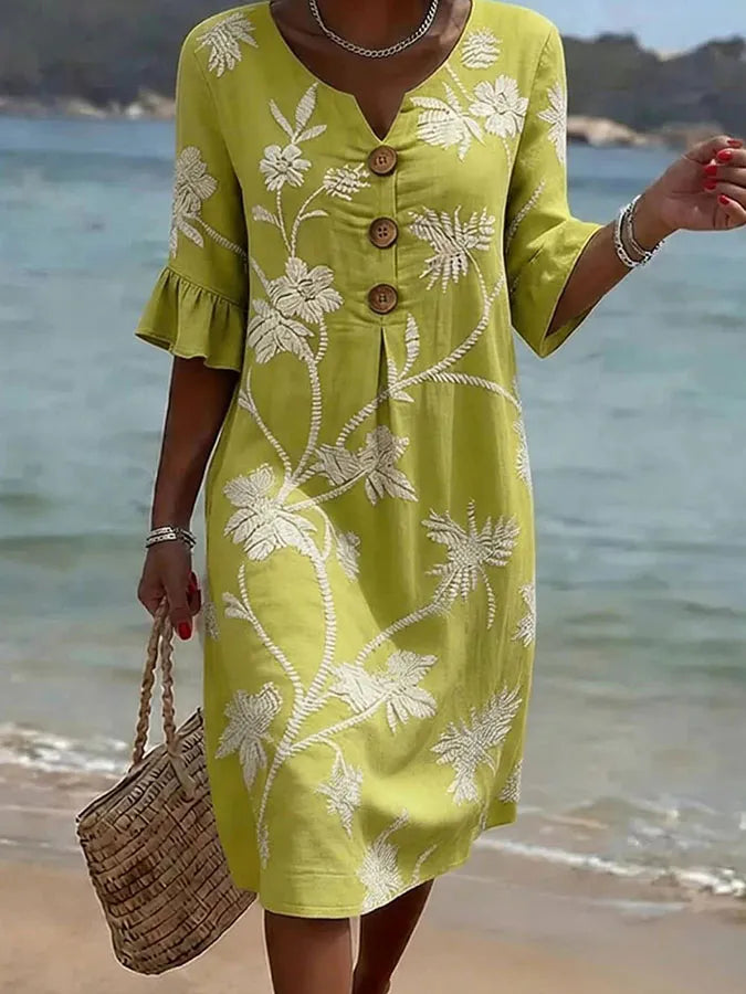 Vestido informal amarillo con flores blancas, cuello pico abotonado y dobladillo con vuelo