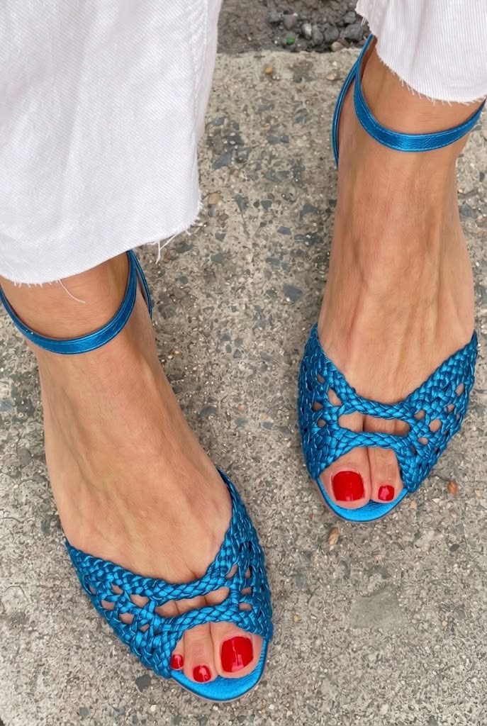 Sandalias azules trenzadas con tira al tobillo y lazo en el empeine, punta abierta.